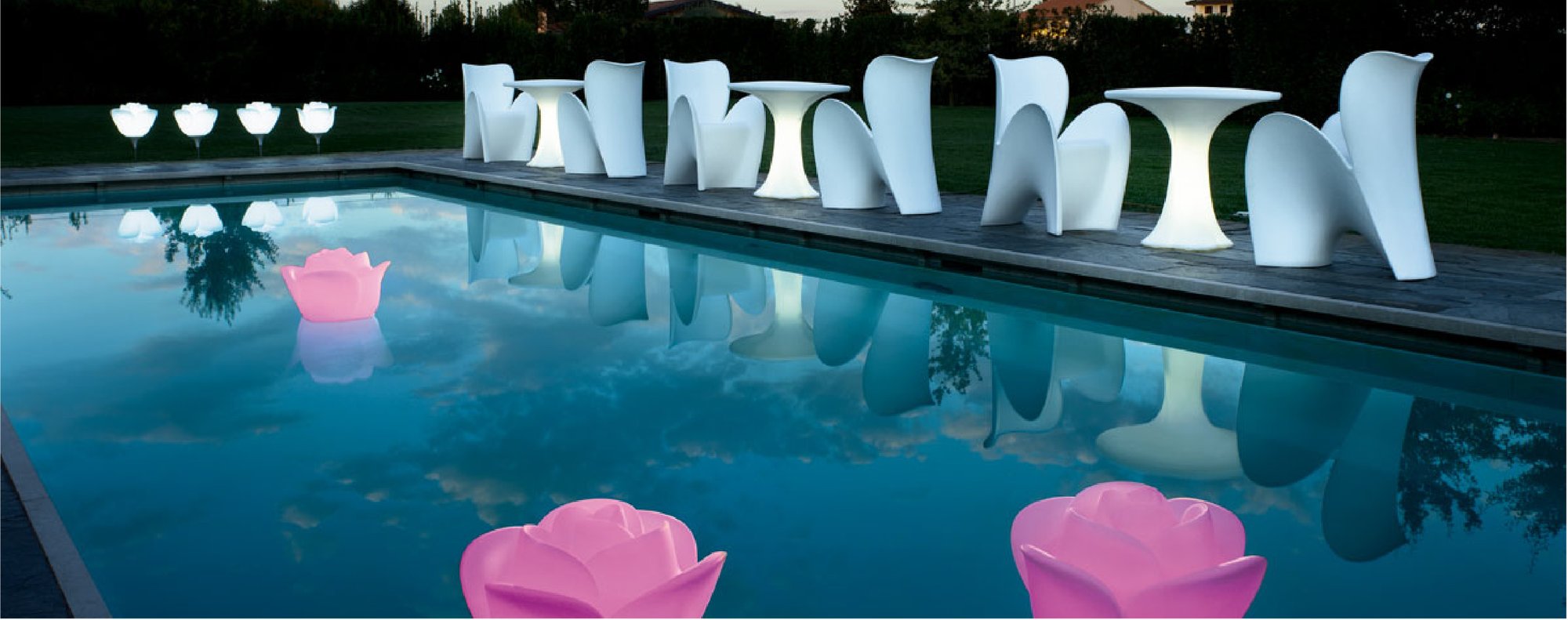 Piscina d’albergo di sera, con sedute luminose sul bordo