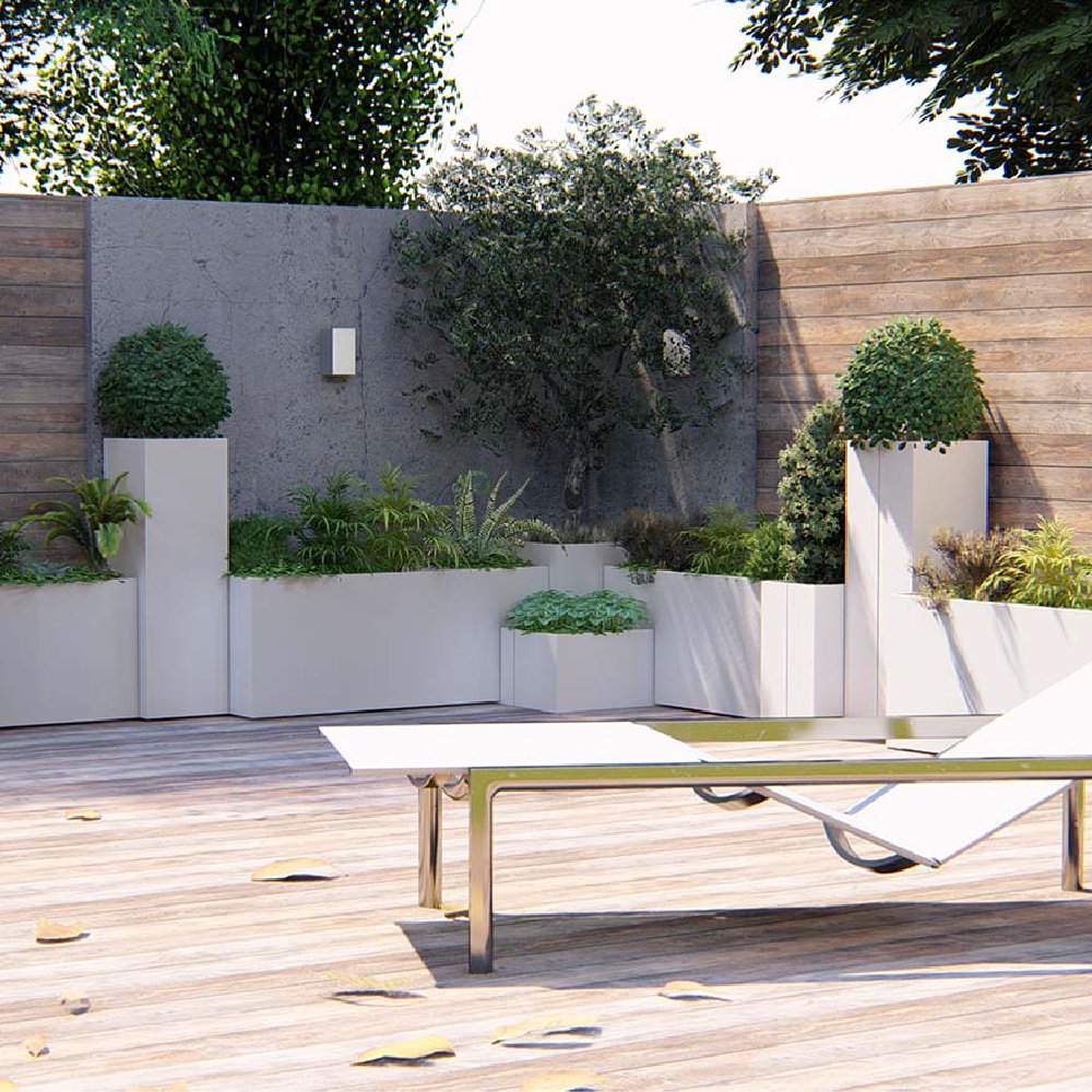 Terrazzo con fioriere bianche Modularte di diverse altezze, piante verdi e una chaise longue