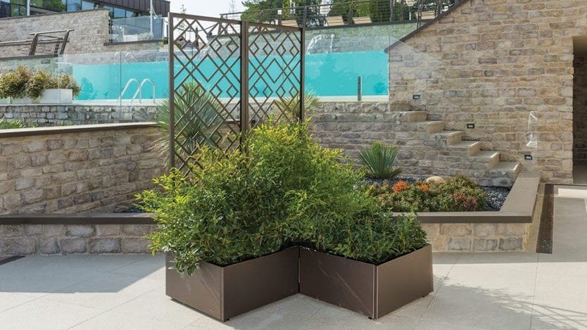 Fioriere Modularte marroni disposte ad angolo con piante, a bordo piscina