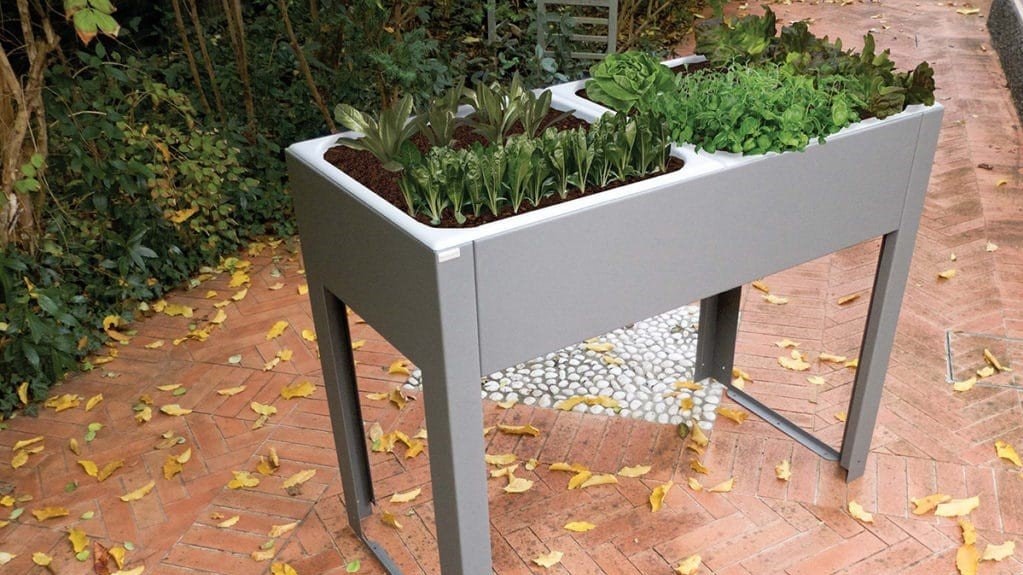 Vaso per orto rialzato Modularte in metallo grigio con ortaggi, su un pavimento in cotto