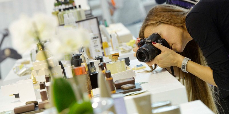 Una visitatrice fotografa i prodotti di cortesia esposti a uno stand di Sia Guest