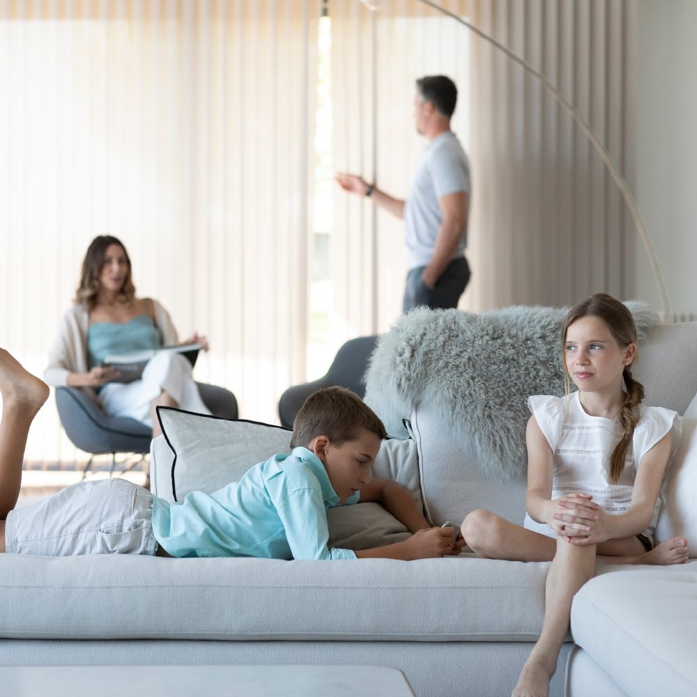 Famiglia sul divano di un soggiorno con tende a rullo alle finestre