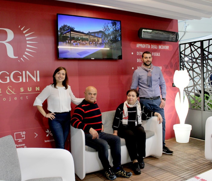 La famiglia Raggini in uno stand dell’azienda, davanti a una parete rossa con il logo