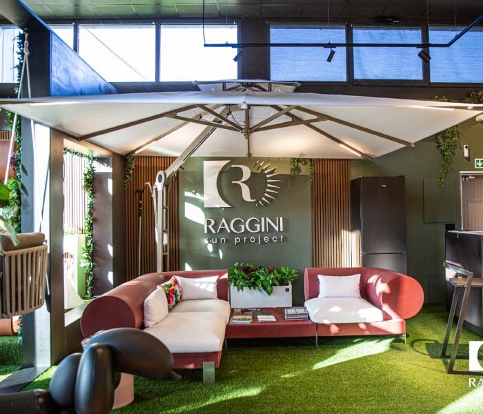 Interno dello showroom Sun Project: salotto da esterno sotto un ombrellone a braccio