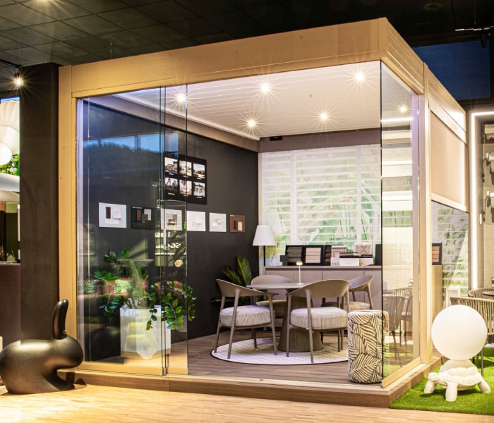Pergola con vetrate allestita con tavolo e sedie all’interno dello showroom Sun Project