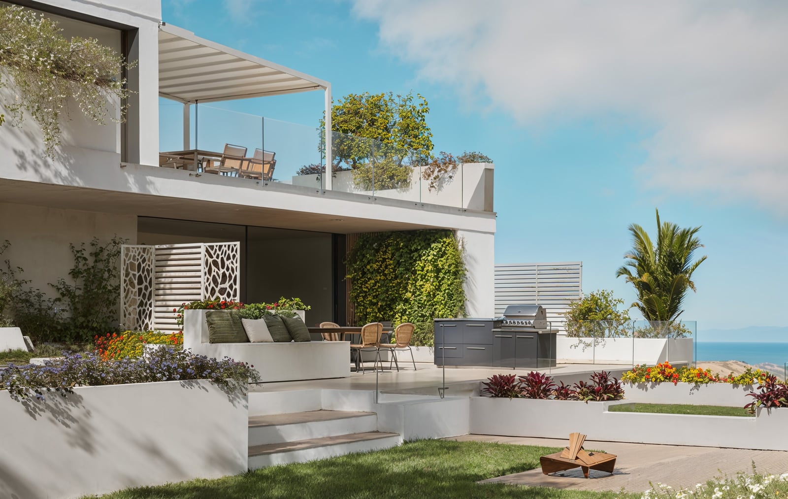 Giardino con salotto e cucina da esterno sulla terrazza di una villa vista mare