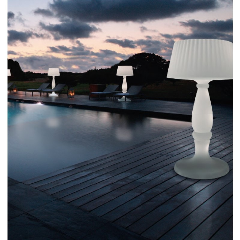 Lampada da terra luminosa su una terrazza in legno a bordo piscina, di sera