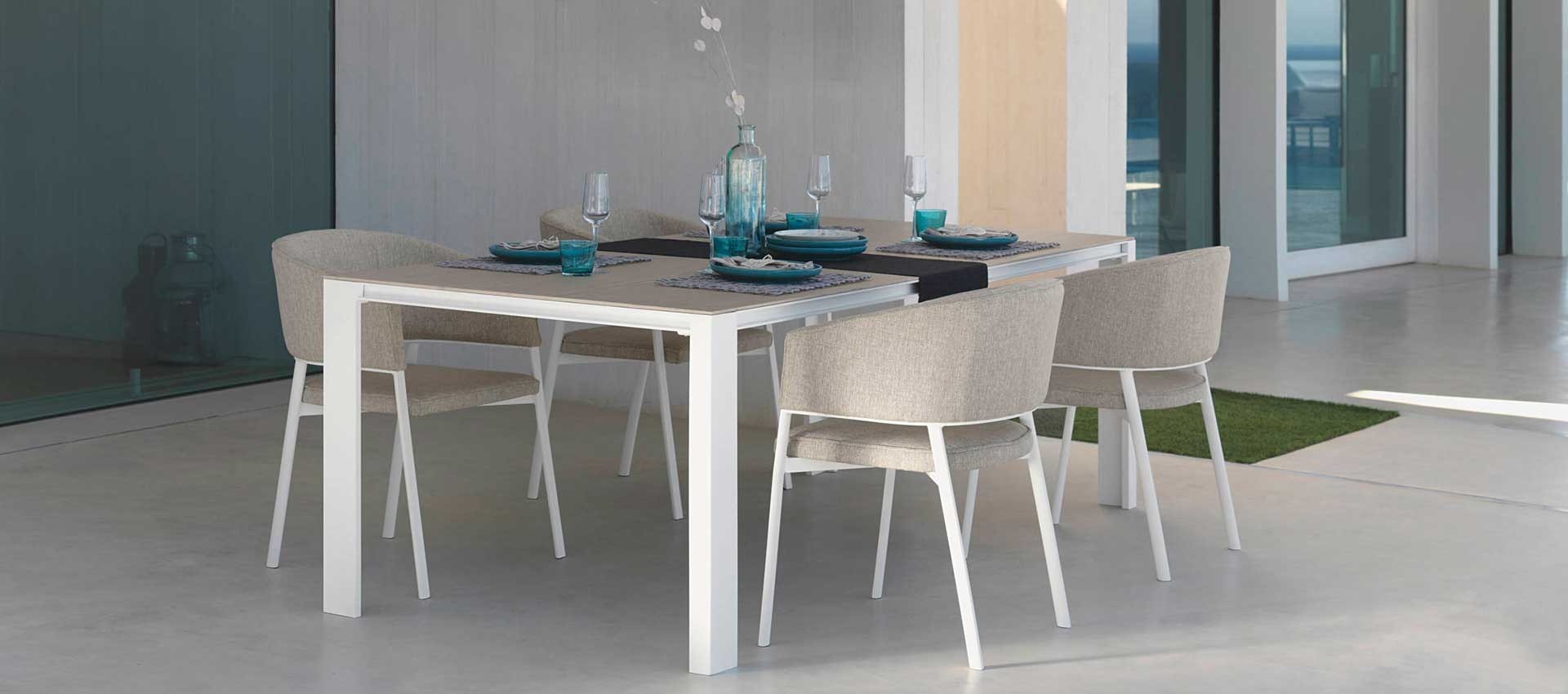 Tavolo da pranzo bianco con sedie imbottite su un patio
