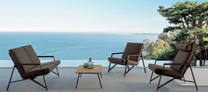 Poltrone marroni e tavolino basso su una terrazza affacciata sul mare