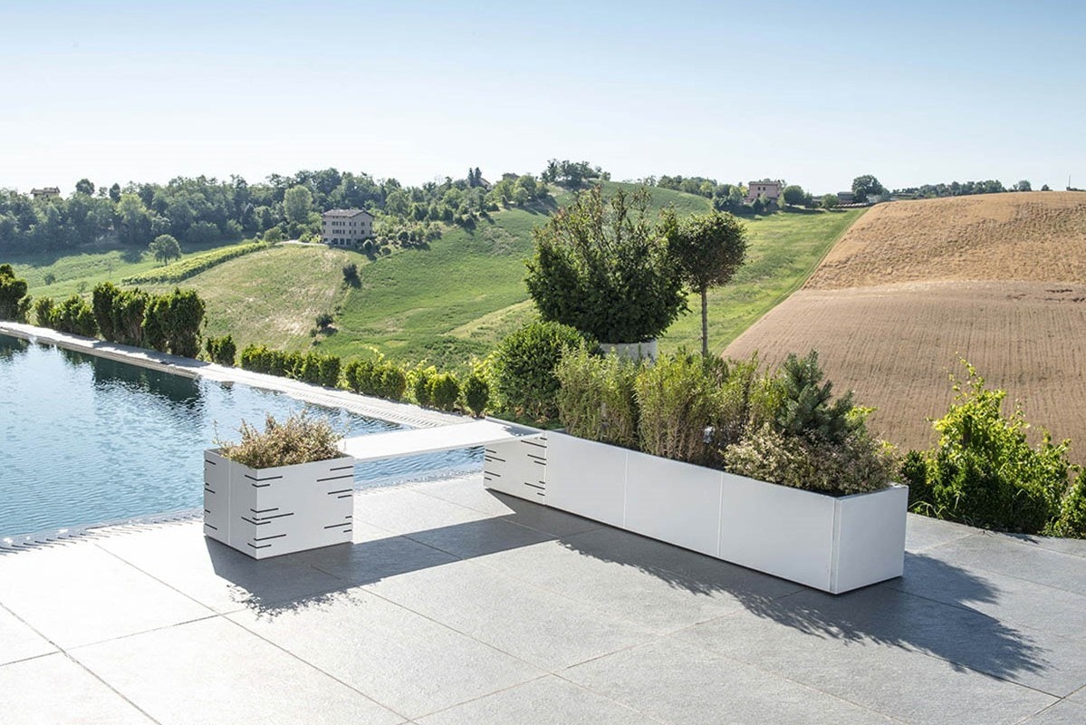Fioriere modulari bianche con arbusti su una terrazza