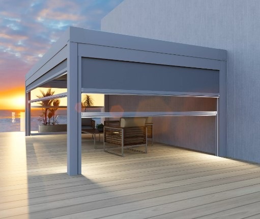 Pergola con tende Delta Double Zip abbassate su una terrazza, al tramonto