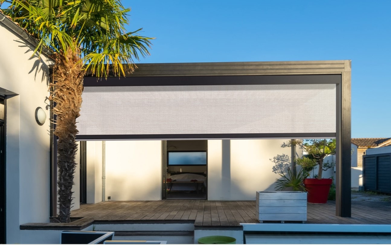 Pergola con tende Ombra abbassate davanti a una casa