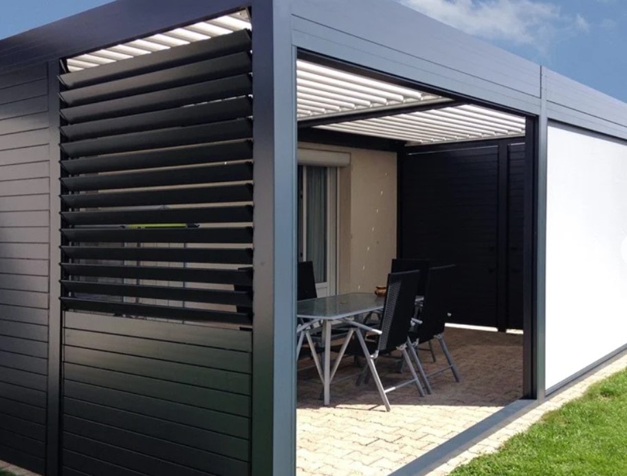 Pergola chiusa su un lato con Shutter antracite, con tavolo in giardino