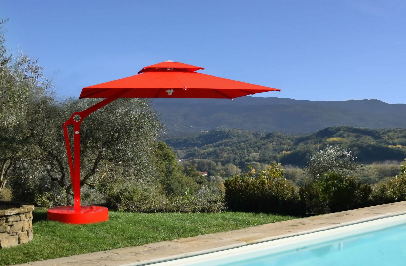Ombrellone Joint rosso a bordo piscina, con vista sulle colline