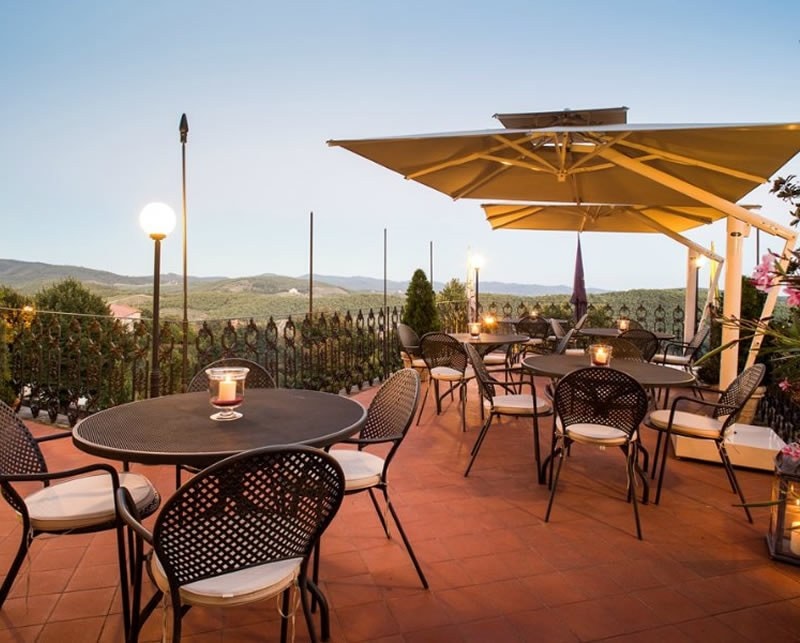 Ombrelloni One sopra i tavoli di una terrazza, al tramonto