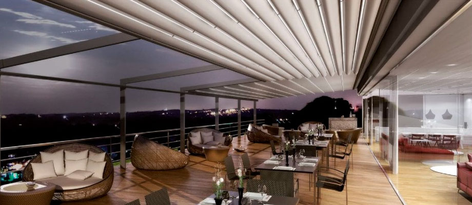 Pergola Artemis su una terrazza con salotto, di sera