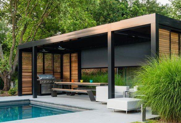 Pergola Camargue a bordo piscina, con barbecue, grigliati in legno e tenda laterale