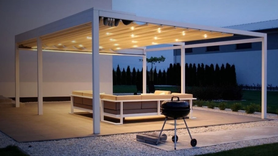 Pergola Olympia illuminata sopra una cucina da esterno, di sera