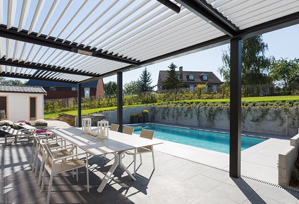Pergola Shadow antracite con tavolo lungo, accanto alla piscina