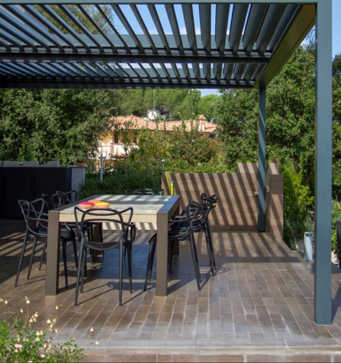 Pergola Shadow antracite su una terrazza con tavolo e sedie
