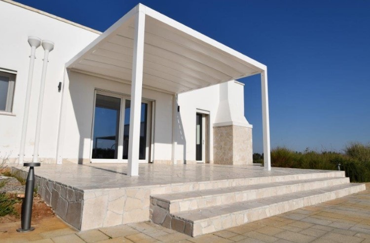 Pergola Tendal Plus bianca sopra un patio con gradini