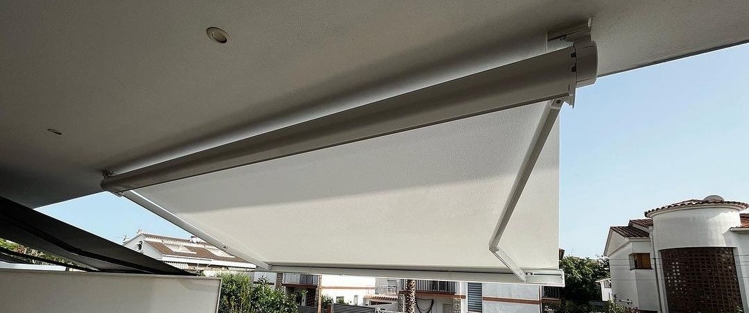 Tenda Armida bianca aperta sotto un balcone, vista dal basso