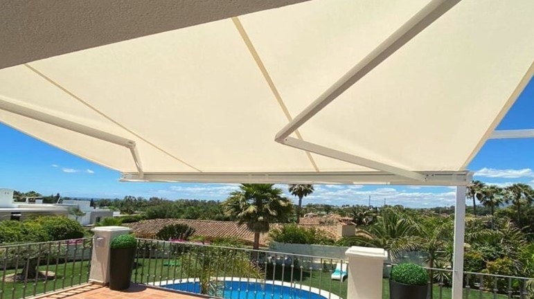 Tenda Elettra bianca su una terrazza affacciata su piscina e giardino