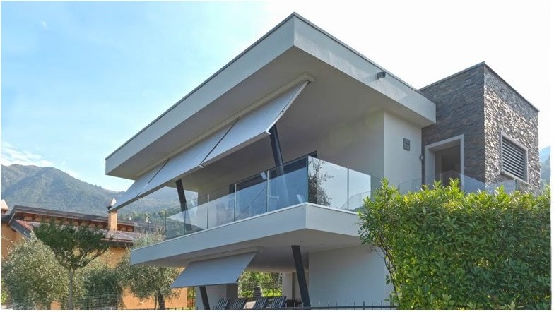 Tende Flat Plus sui balconi di una palazzina moderna, fra le montagne