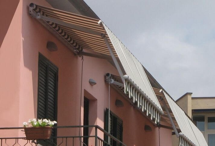 Tende Grandangolo a righe sui balconi di una casa rosa