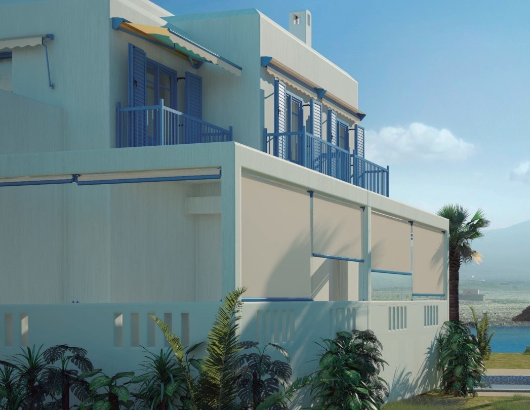 Tende Helios sulle finestre di una casa bianca al mare, fra le palme