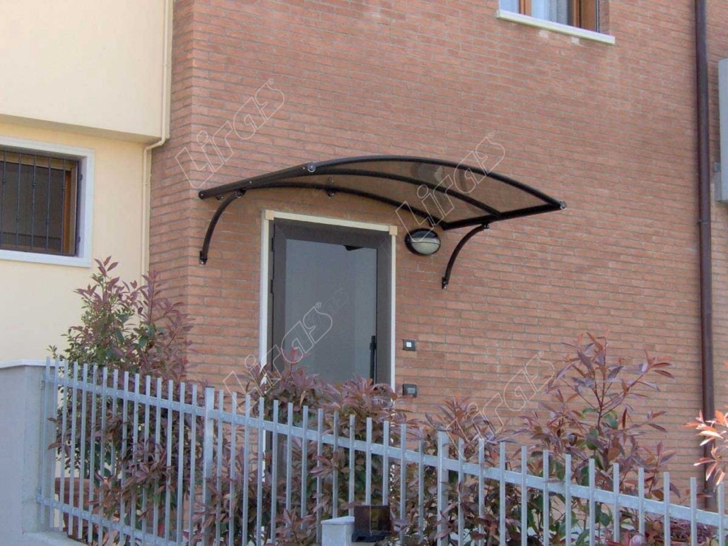 Pensilina a vela scura sopra la porta di una casa in mattoni