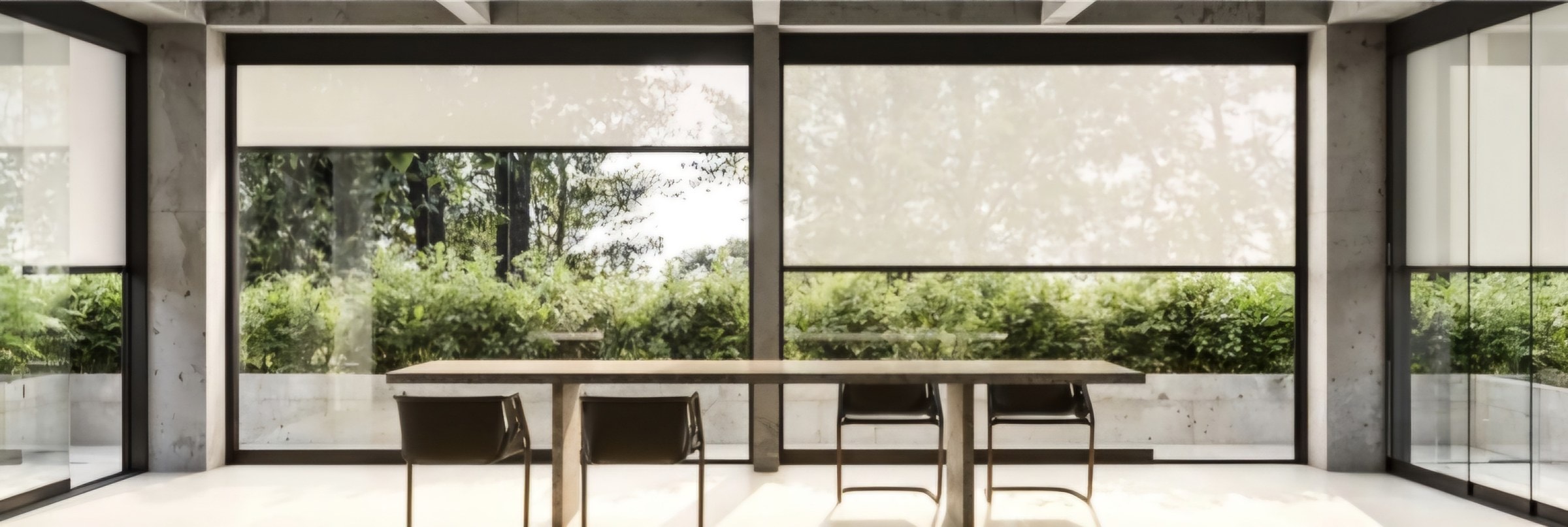 Sala da pranzo con tende Screen Plus sulle vetrate aperte sul verde