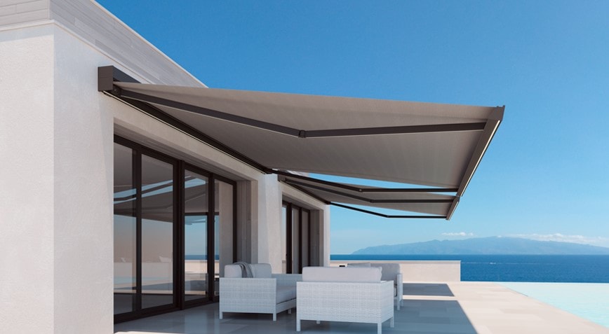 Tenda a bracci grigia aperta su una terrazza vista mare