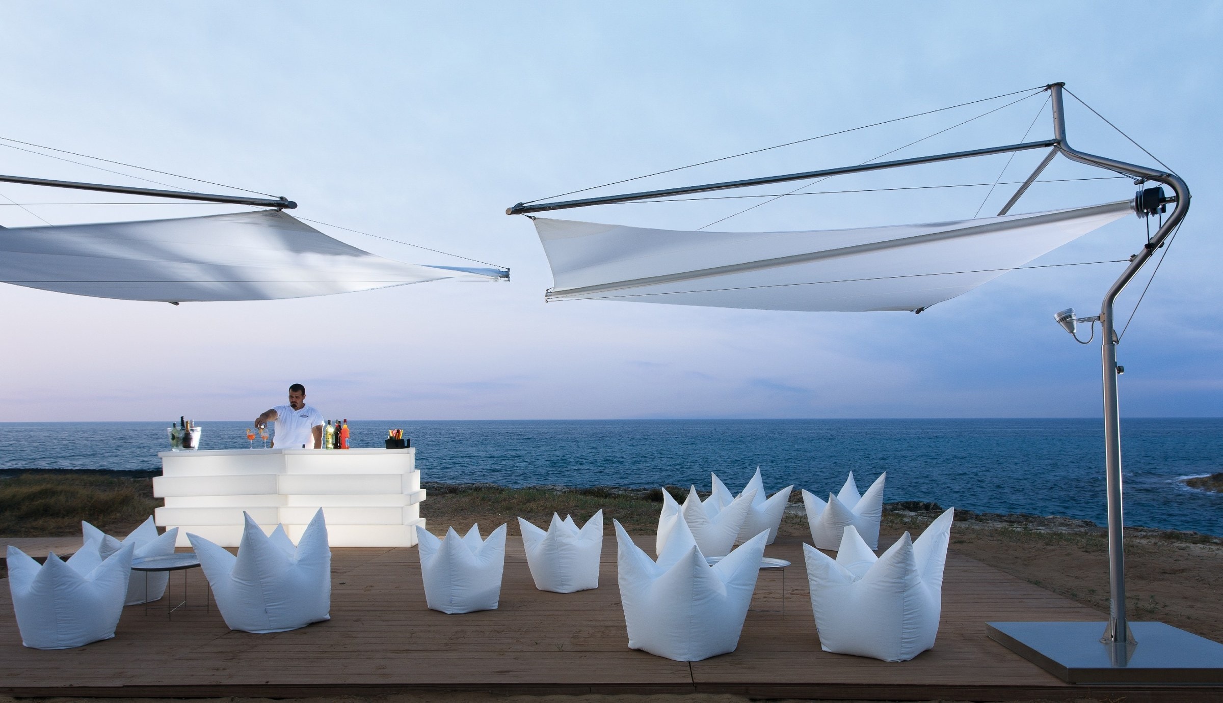 Due vele Ponente su una terrazza sul mare, all’imbrunire