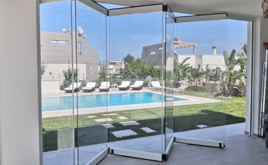 Vetrate a pacchetto aperte su un lato, affacciate su una piscina in giardino