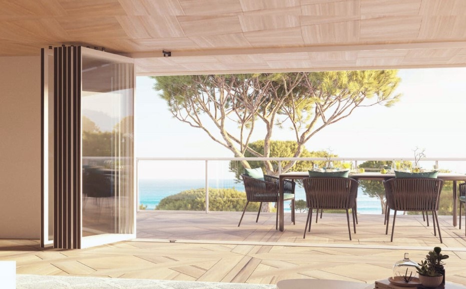 Ante Flip Glass raccolte su un lato di una terrazza vista mare, con tavolo da pranzo