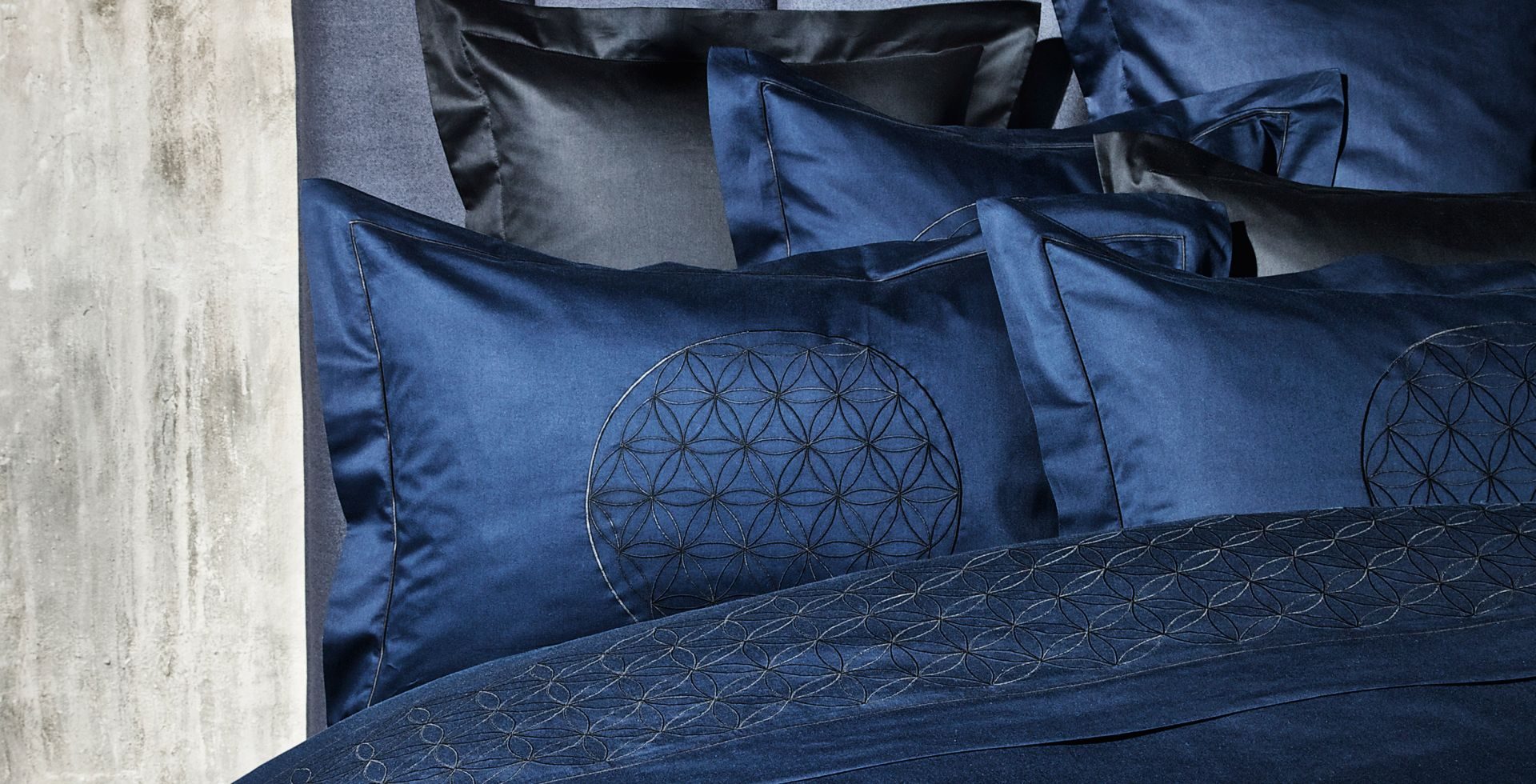 Cuscini blu con ricami geometrici e bordi in raso