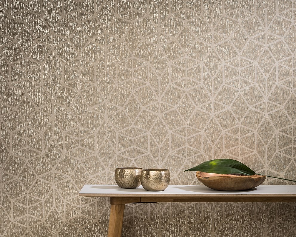 Parete beige a trama geometrica con ciotole di metallo su una panca