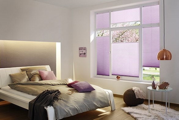 Camera da letto con tende plissè lilla alla finestra