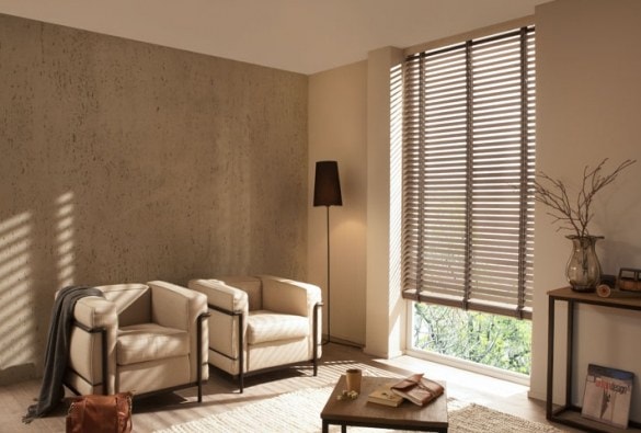 Salotto beige con due poltrone e veneziane in legno scuro
