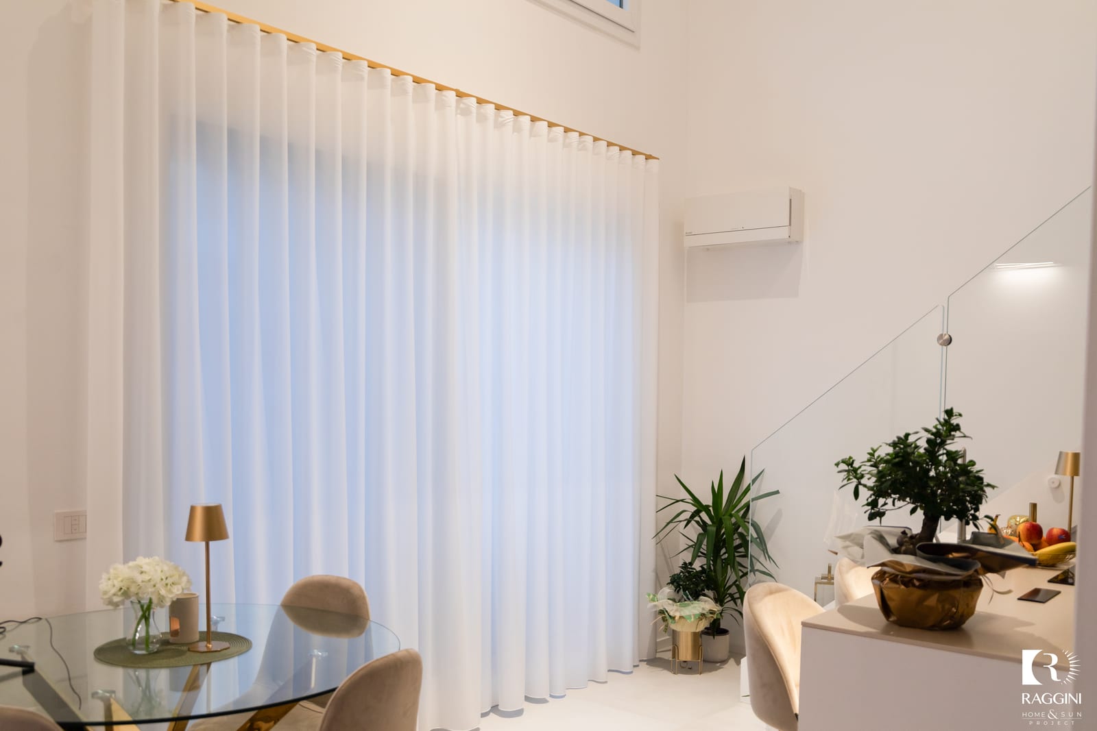Soggiorno di Casa F con tende in georgette avorio e profilo in alluminio oro satinato