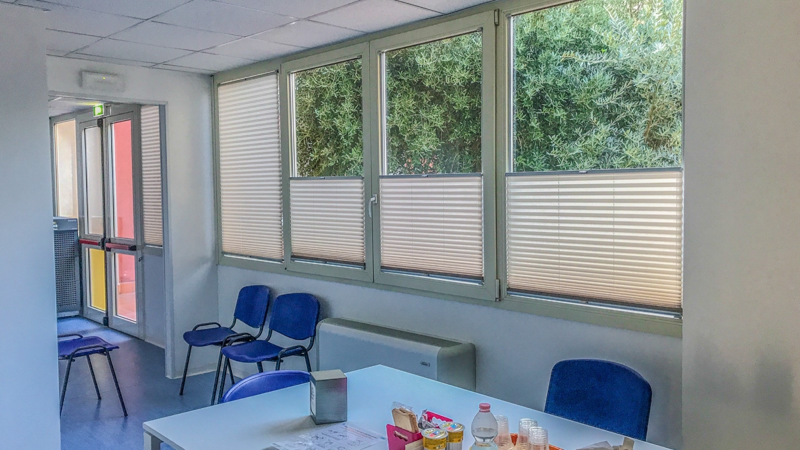 Sala dell'Avis di Cattolica con tende plissé chiare sulle finestre