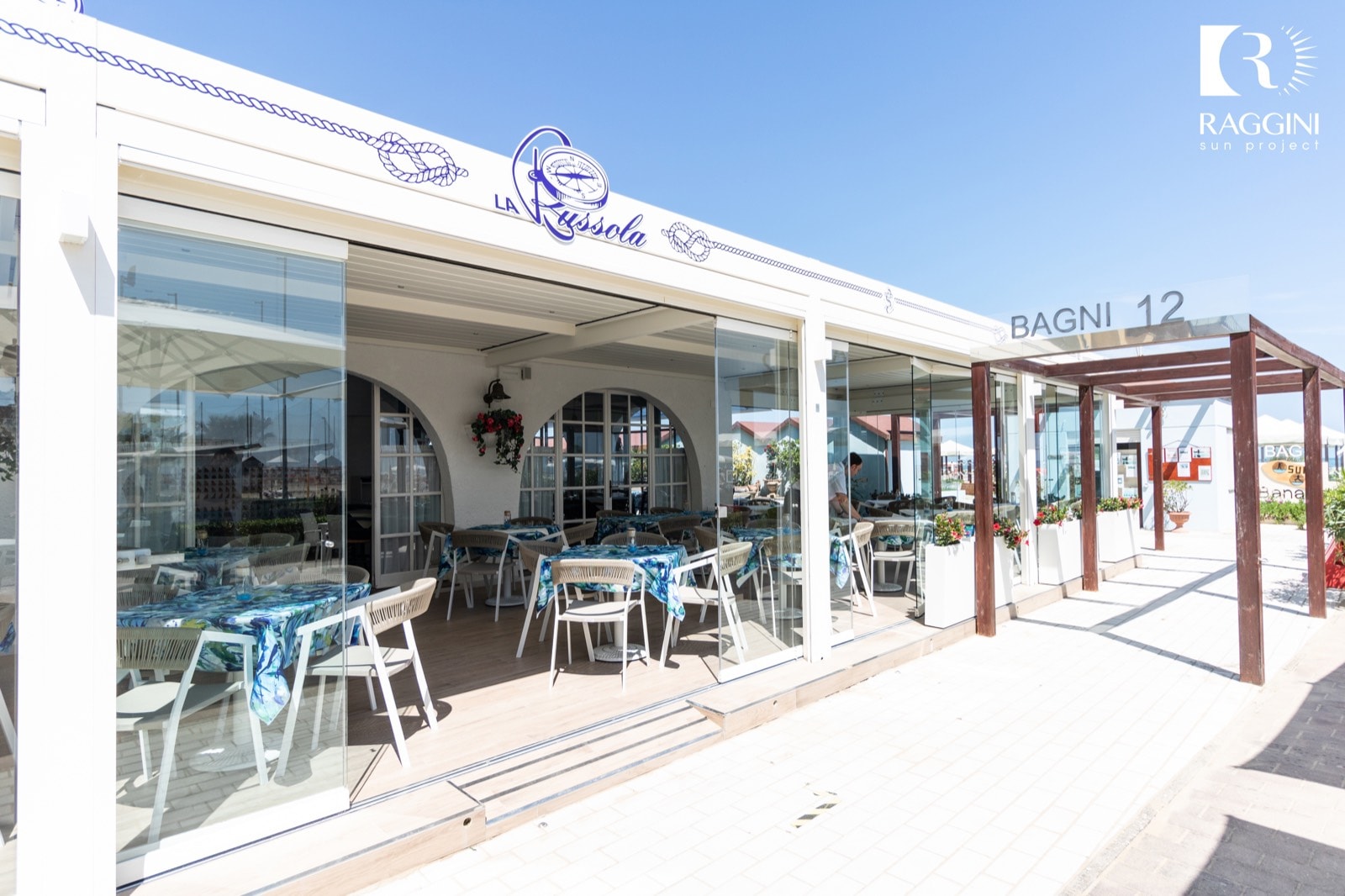 Dehors del Ristorante La Bussola sotto la pergola bioclimatica, chiuso da vetrate