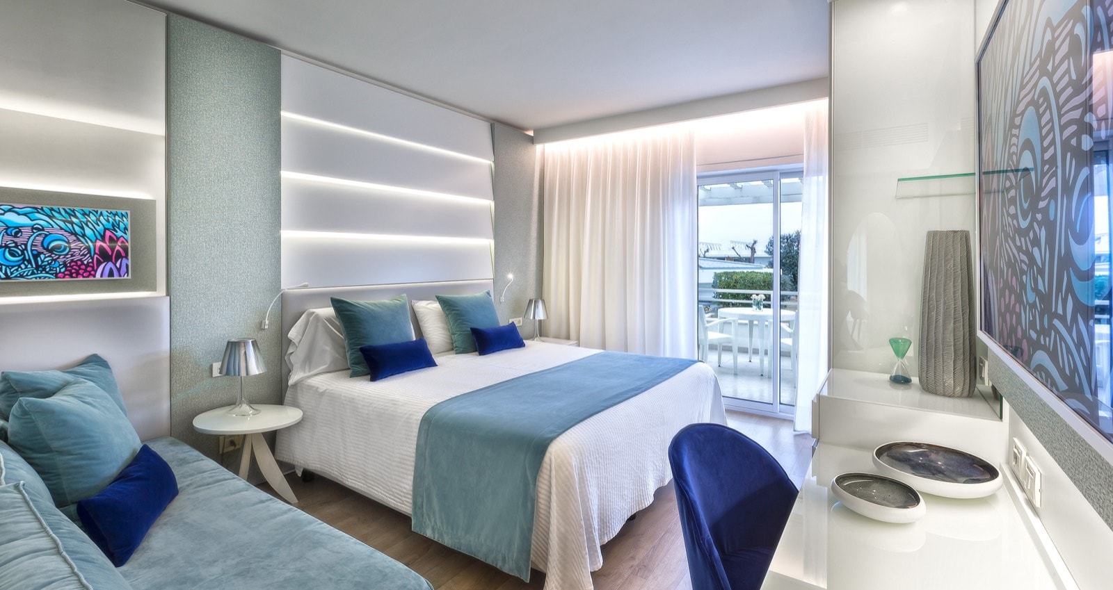 Camera dell’Hotel Atlantic con tende bianche e cuscini blu