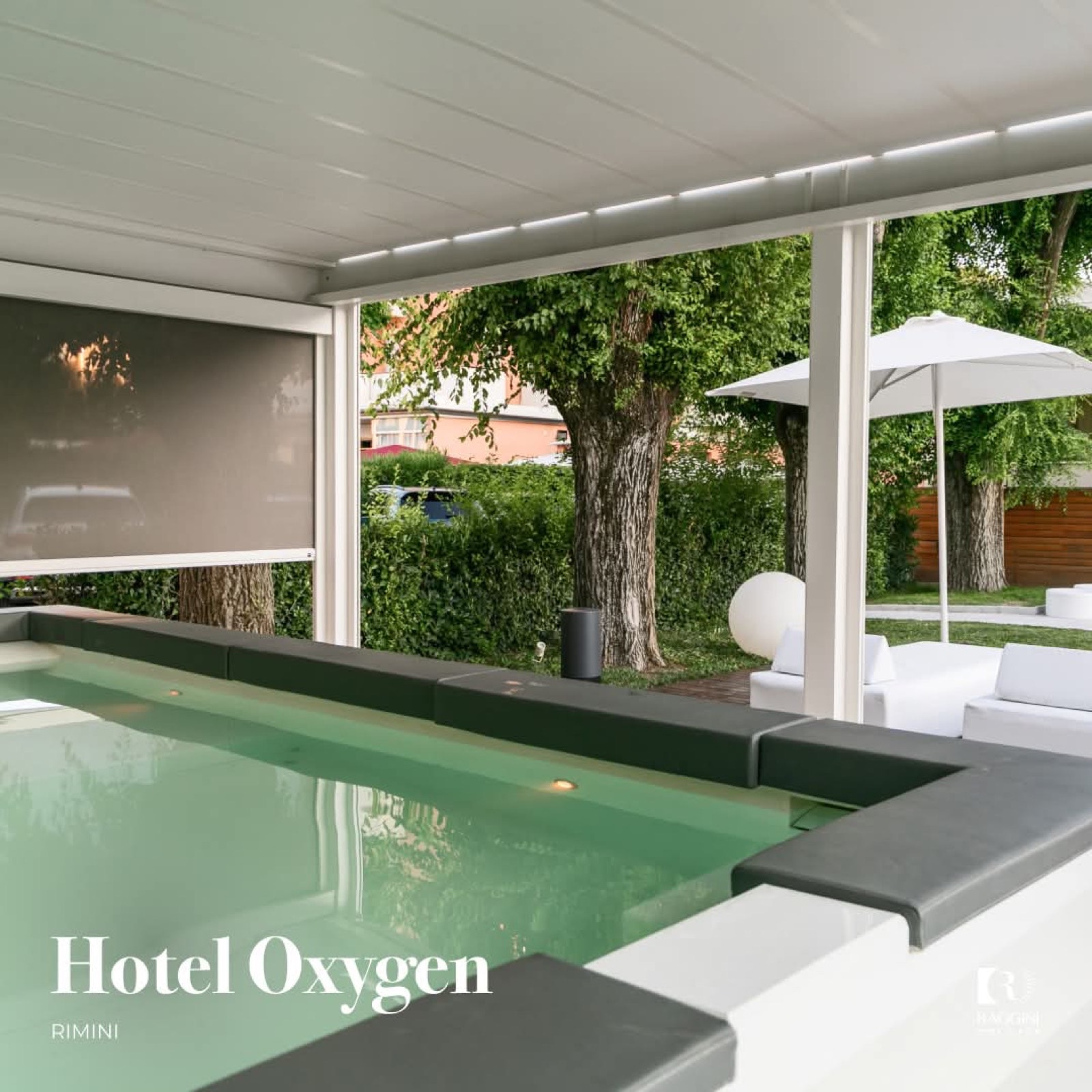 Pergola bianca con tende laterali a bordo piscina dell'Hotel Oxygen