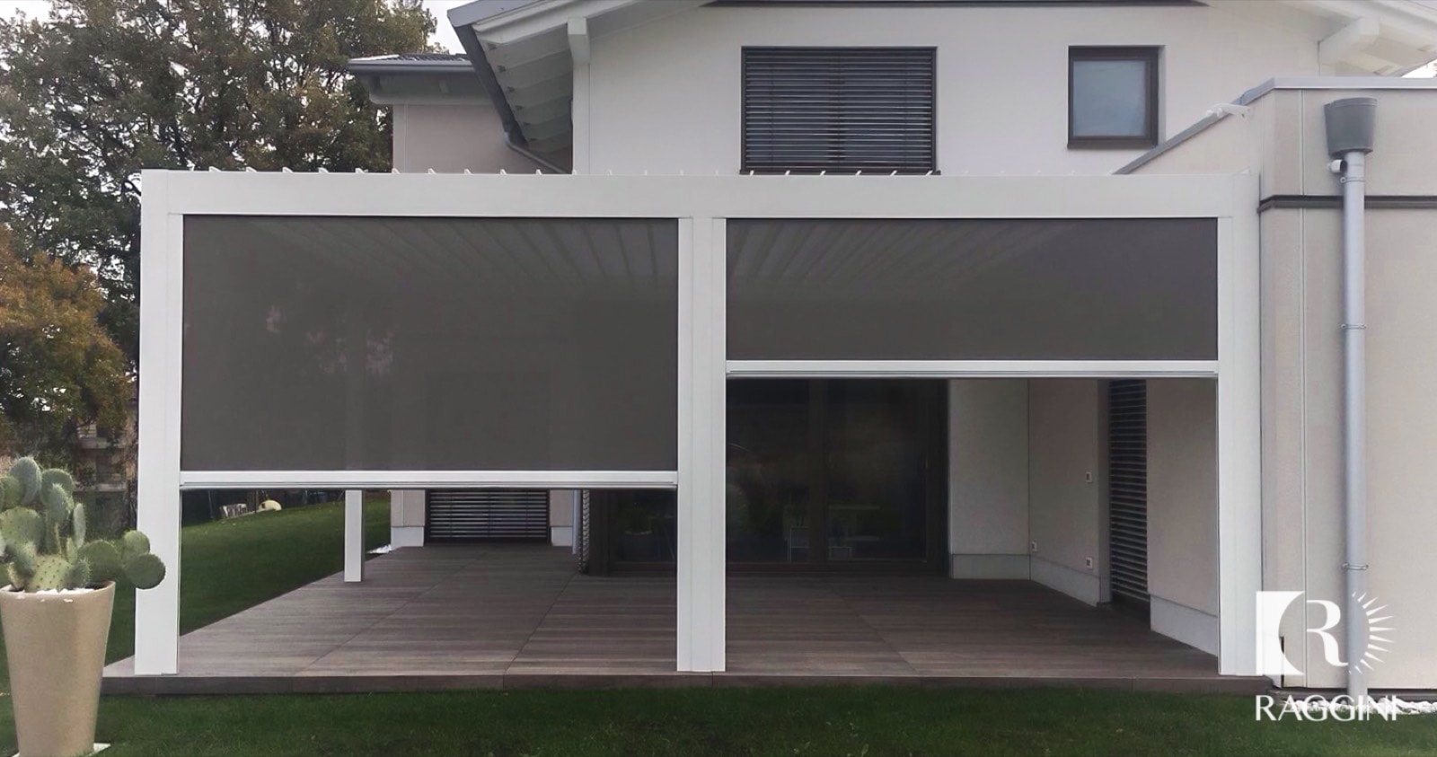 Pergola bioclimatica bianca con tende windy abbassate davanti a una casa