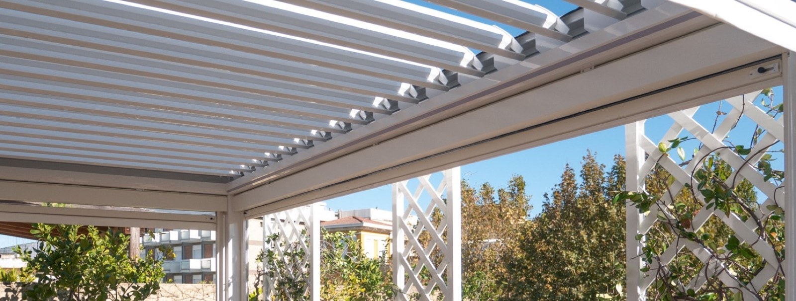 Pergola bioclimatica bianca con fioriere e grigliati per le piante su una terrazza