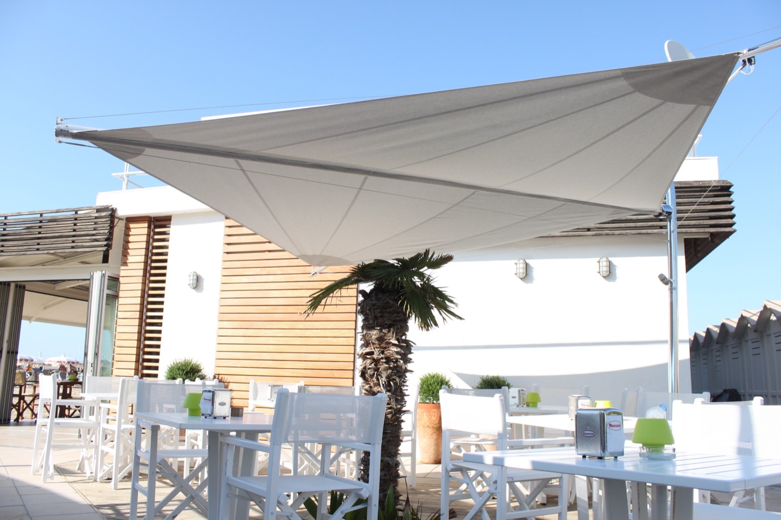 Vela ombreggiante grigia sopra i tavoli del Ristorante Sirena