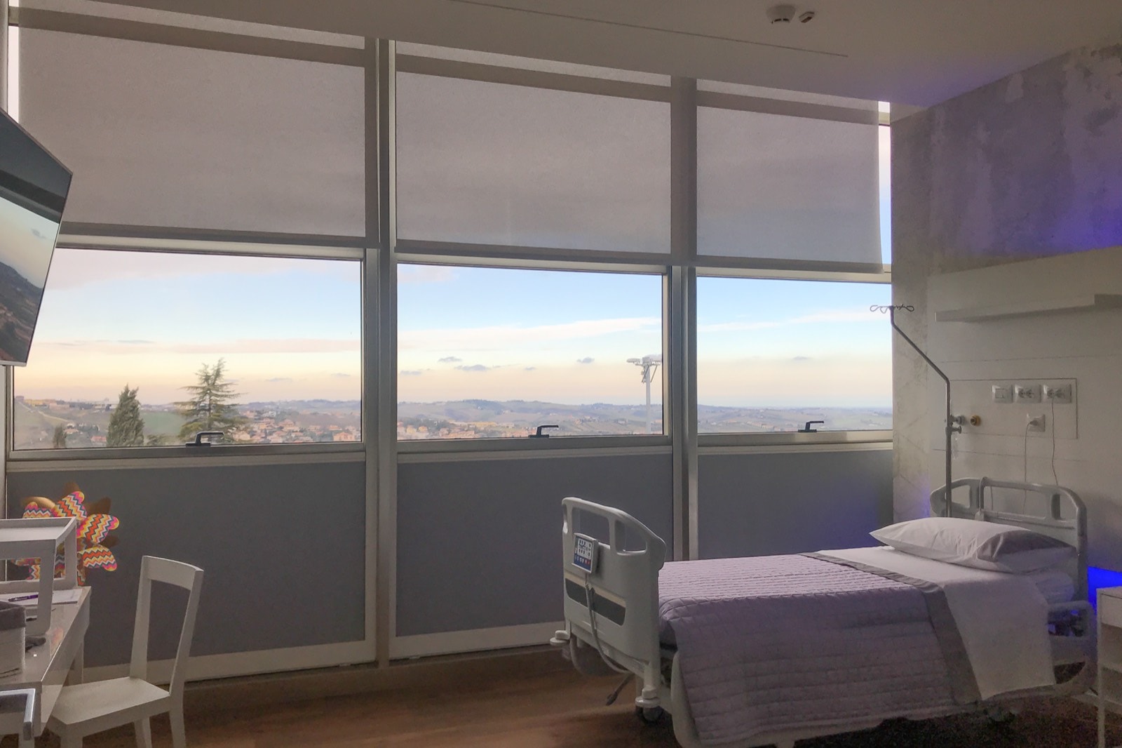 Camera di degenza di Tiss'you Care con tende tecniche e vista sulle colline