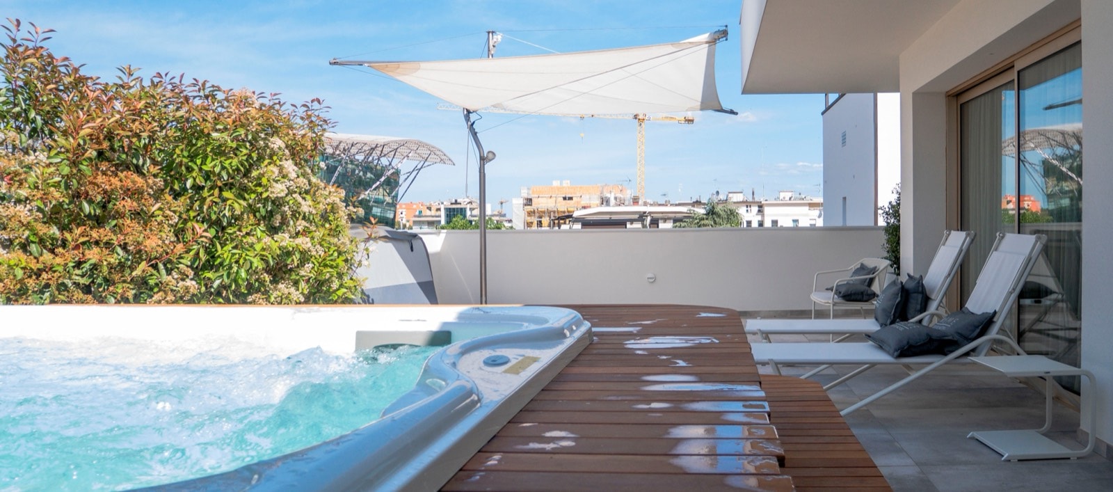 Terrazzo della suite con mini spa Jacuzzi, fioriere e vela ombreggiante